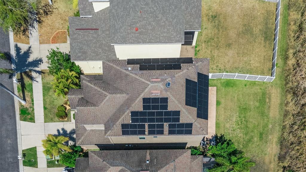 An aerial view shows a residential roof with multiple solar panel arrays installed — 521 VISTA RIDGE DRIVE, RUSKIN, FL