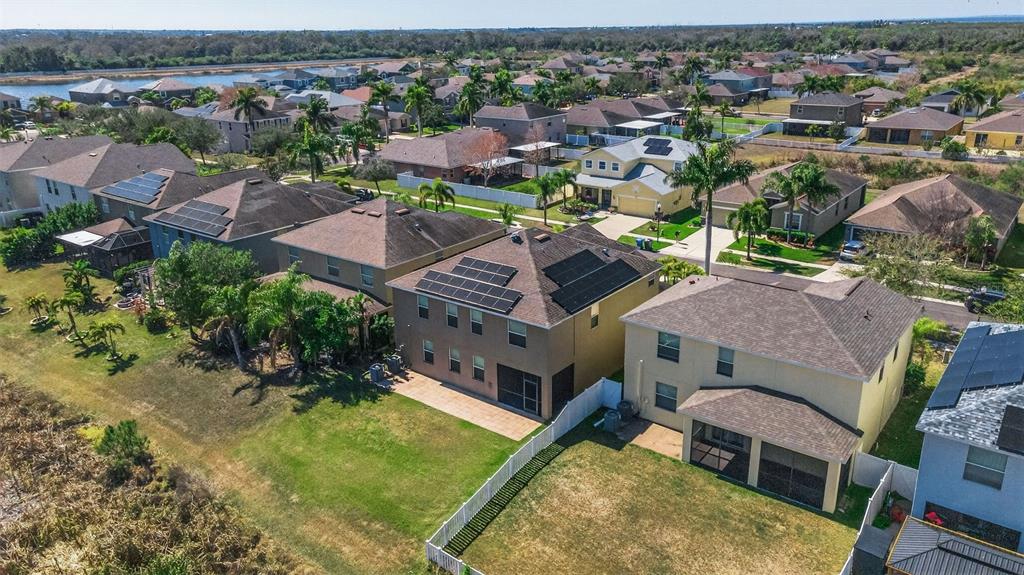 An aerial view shows a suburban neighborhood with several houses featuring solar panels on roofs — 521 VISTA RIDGE DRIVE, RUSKIN, FL