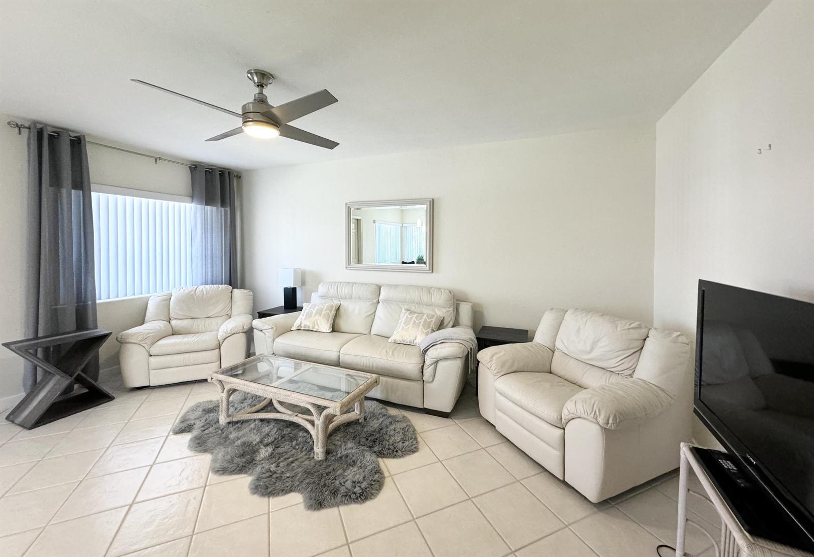 A living room features white leather furniture, a glass coffee table, and a gray rug — 2880 Lake Osborne Drive # 205, FL 33461, FL