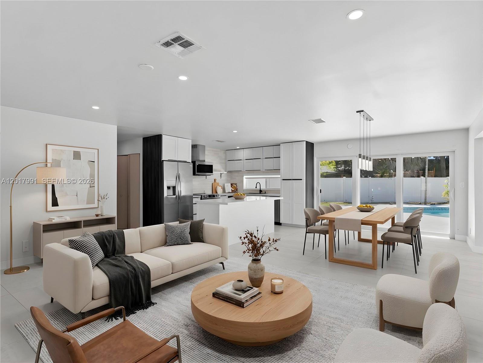 An open-concept living and dining area features modern white cabinetry, a kitchen island, and pool views — 421 S 56th Ter, Hollywood FL 33023, HOLLYWOOD, FL