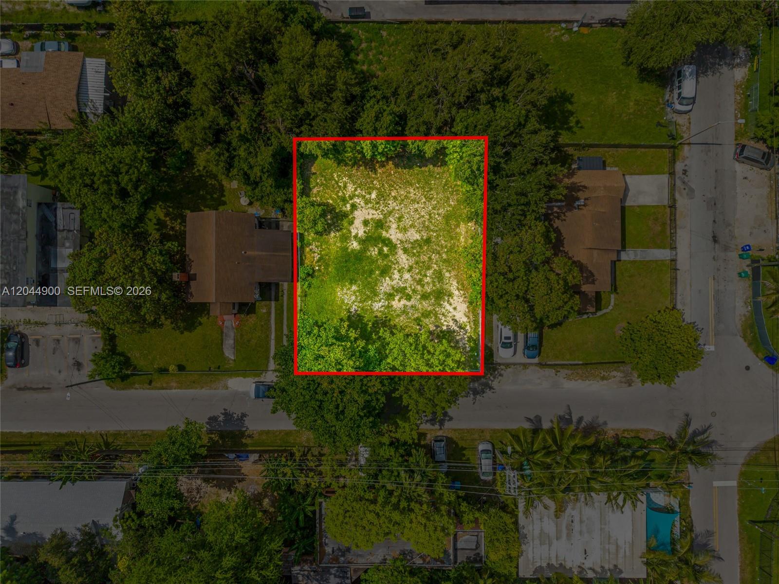 An aerial view shows a rectangular, vacant lot surrounded by trees and neighboring residential houses — 60 NE 76th St, Miami FL 33138, MIAMI, FL