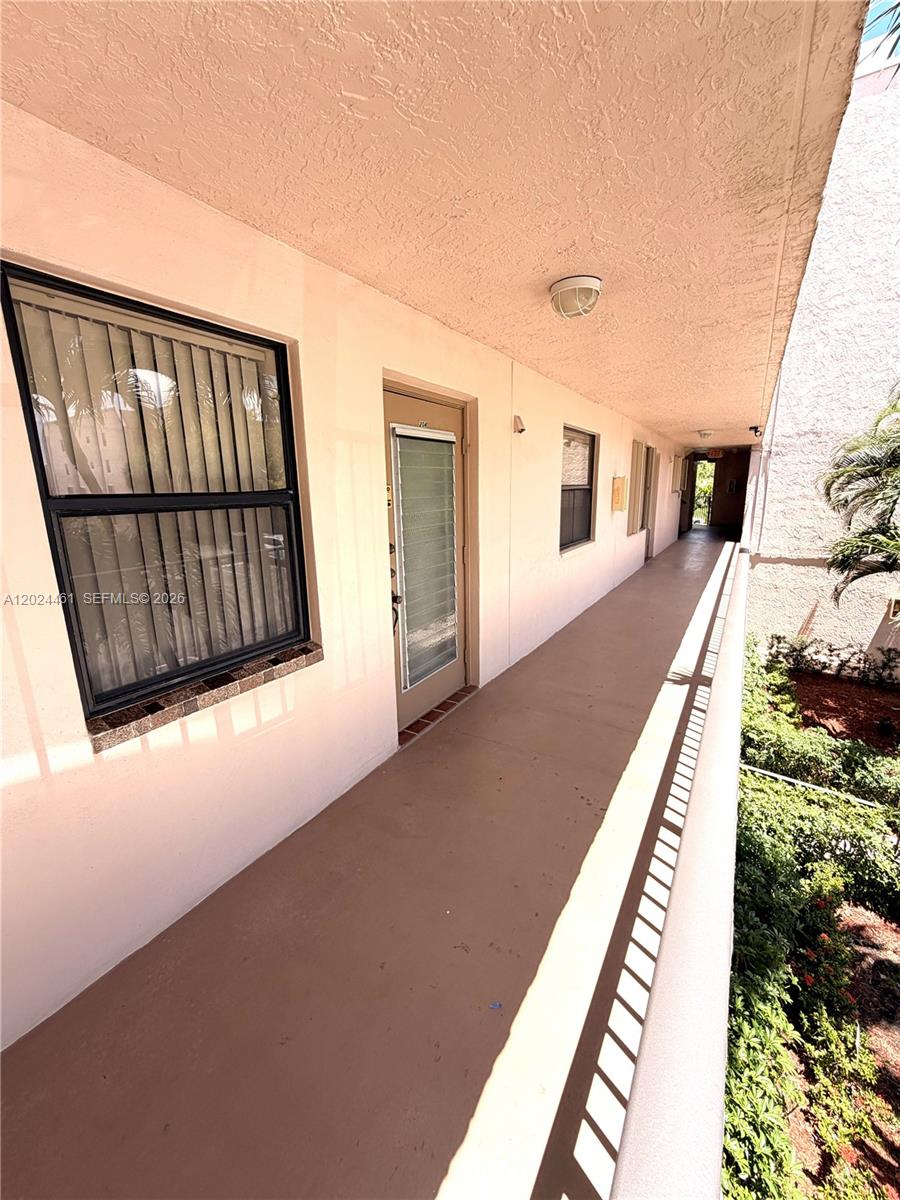 An outdoor walkway leads past apartment doors and windows along a building exterior — 2793 NW 104th Ave # 204, Sunrise FL 33322, SUNRISE, FL