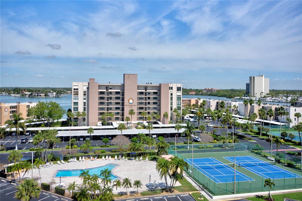 A multi-story apartment building features a covered parking lot with several parked cars — 7600 SUN ISLAND DRIVE S UNIT 804, SOUTH PASADENA, FL