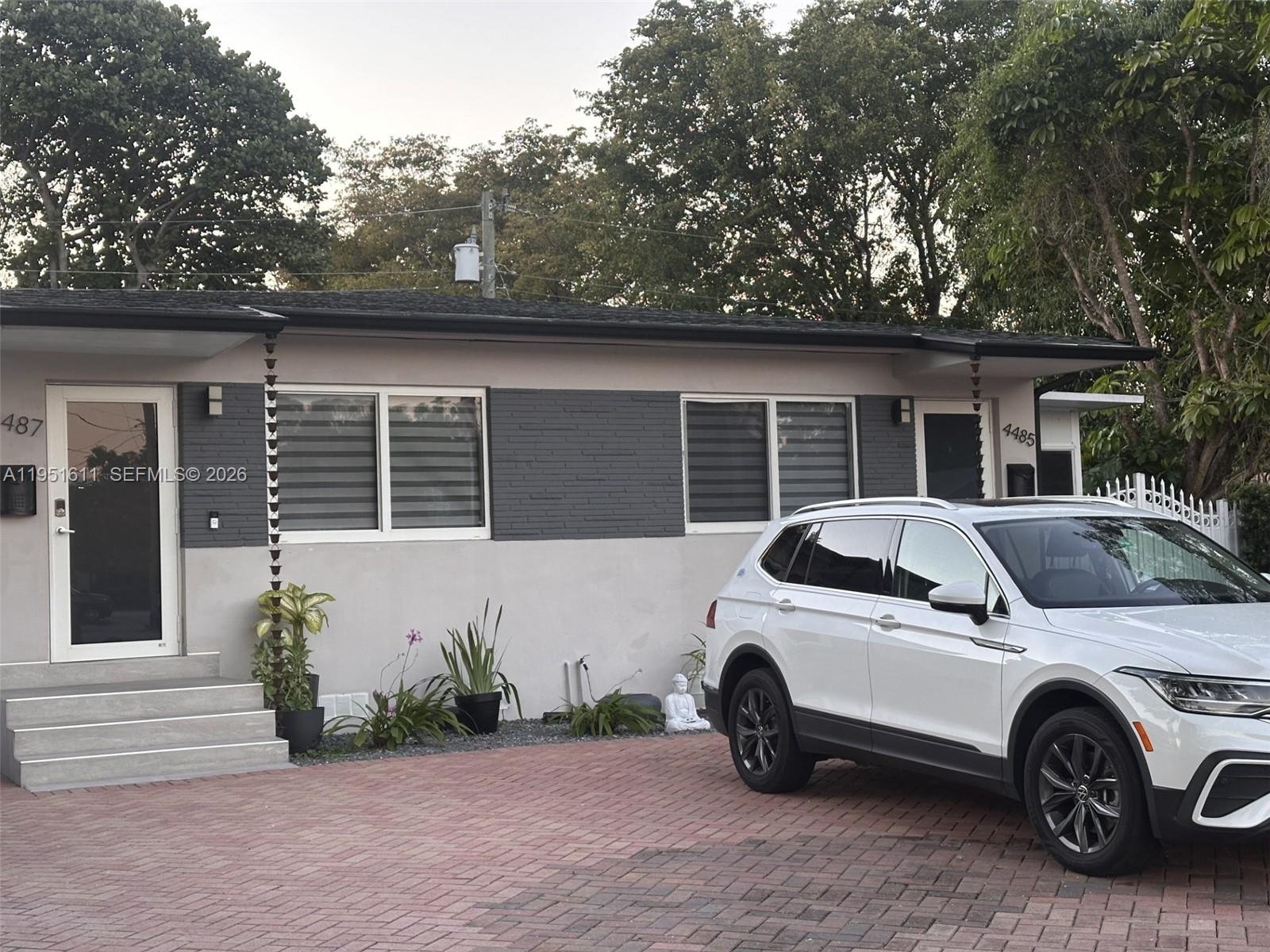 A white SUV is parked on a brick driveway in front of a duplex exterior — 4485 SW 7th St, Miami FL 33134, MIAMI, FL