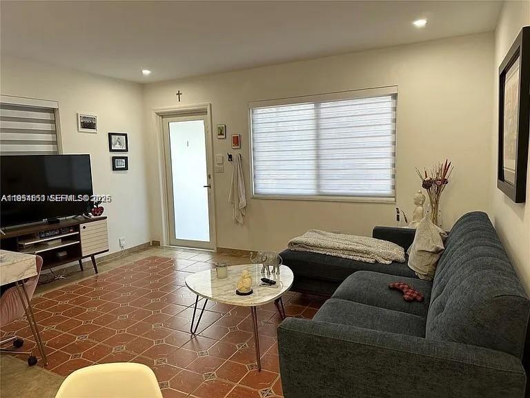 A living room features a gray sofa, a coffee table, and a television on a stand — 4485 SW 7th St, Miami FL 33134, MIAMI, FL
