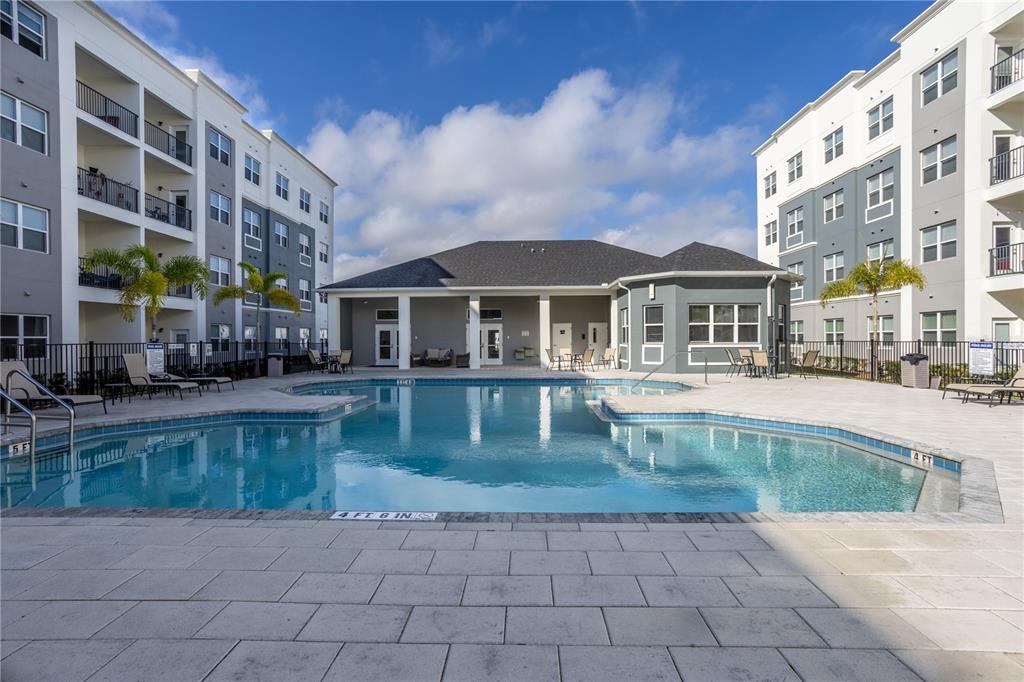 A swimming pool sits in the courtyard between two large apartment buildings — 1230 SOUTHSTATION PLACE UNIT 306, ORLANDO, FL