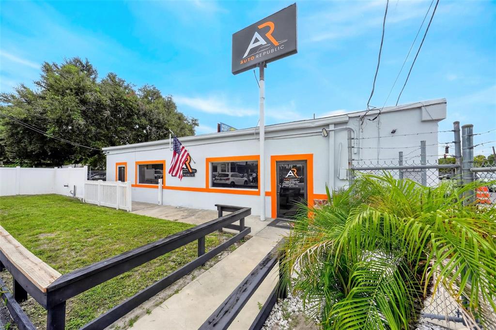 The exterior of a white commercial building features orange trim, a large sign, and landscaping — 2906 N ORANGE BLOSSOM TRAIL, ORLANDO, FL