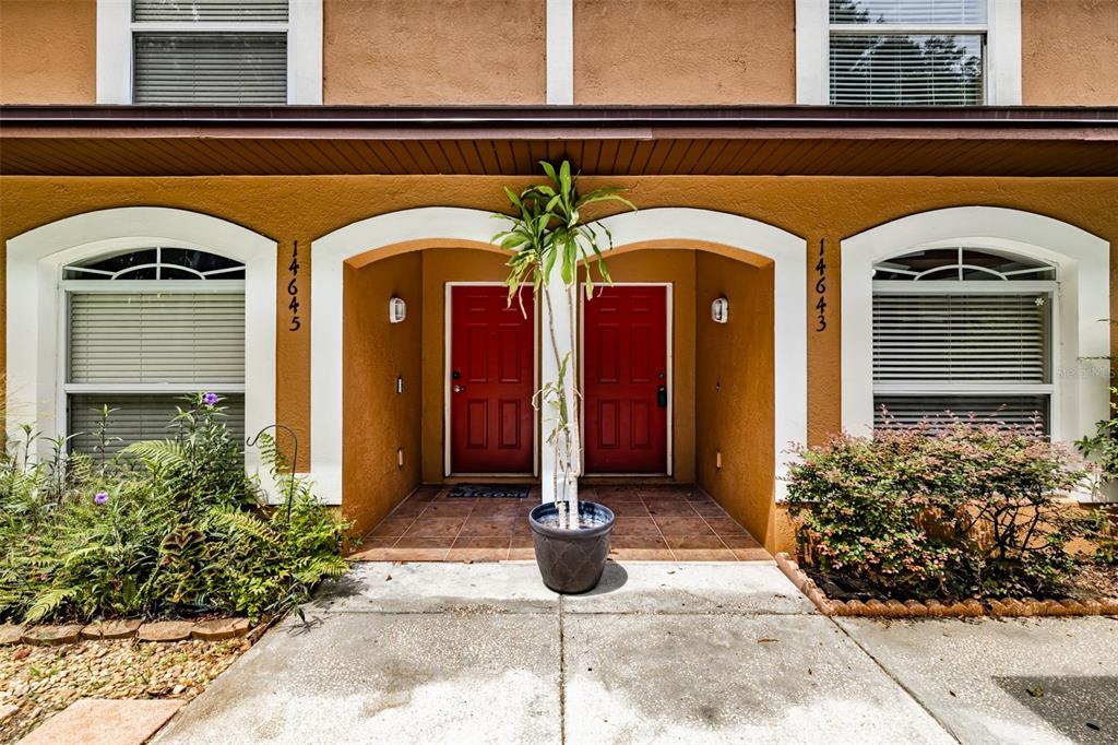 The exterior of a duplex features two red front doors and arched windows — 14643 PAR CLUB CIRCLE UNIT 14643, TAMPA, FL