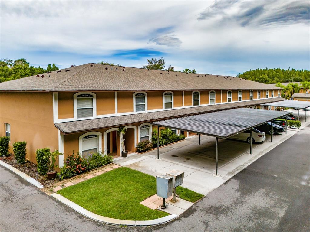 An exterior view of a two-story apartment building with a covered parking area — 14643 PAR CLUB CIRCLE UNIT 14643, TAMPA, FL