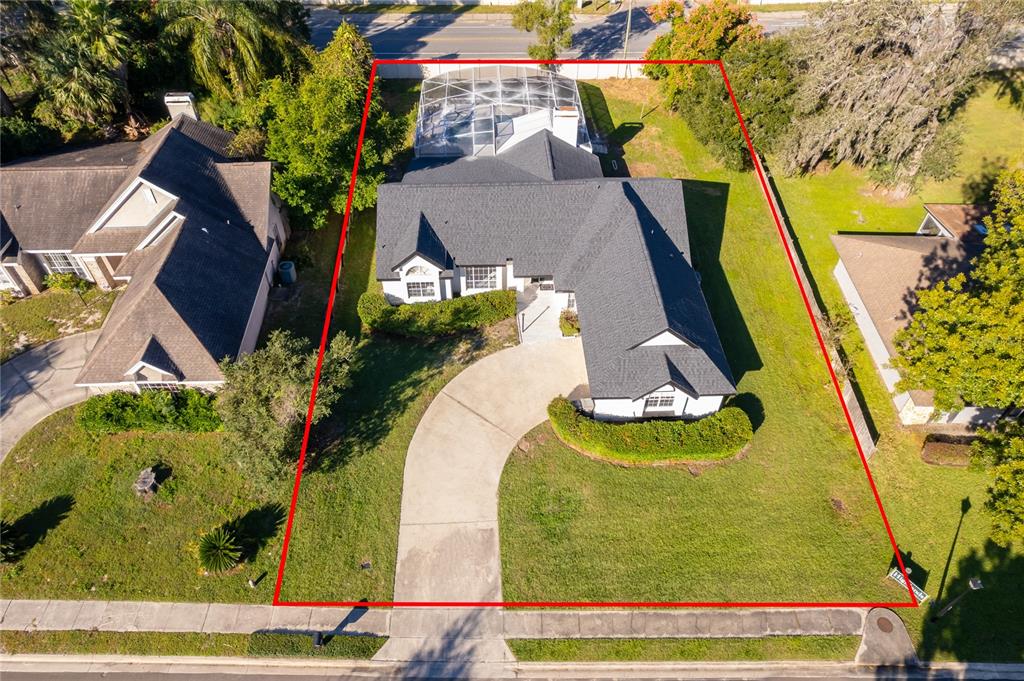 A single-story house with a white exterior, dark roof, and a large front lawn — 1250 GLENMORE DRIVE, APOPKA, FL