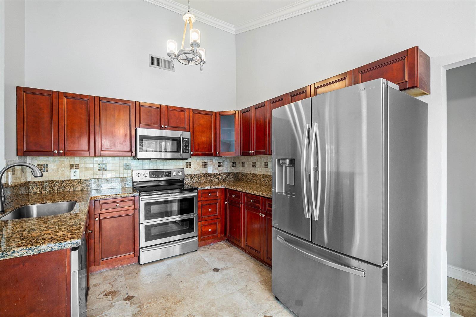 A kitchen features cherry wood cabinets, granite countertops, stainless steel appliances, and tile flooring — 8411 Garden Gate Place, Boca Raton FL 33433, BOCA RATON, FL