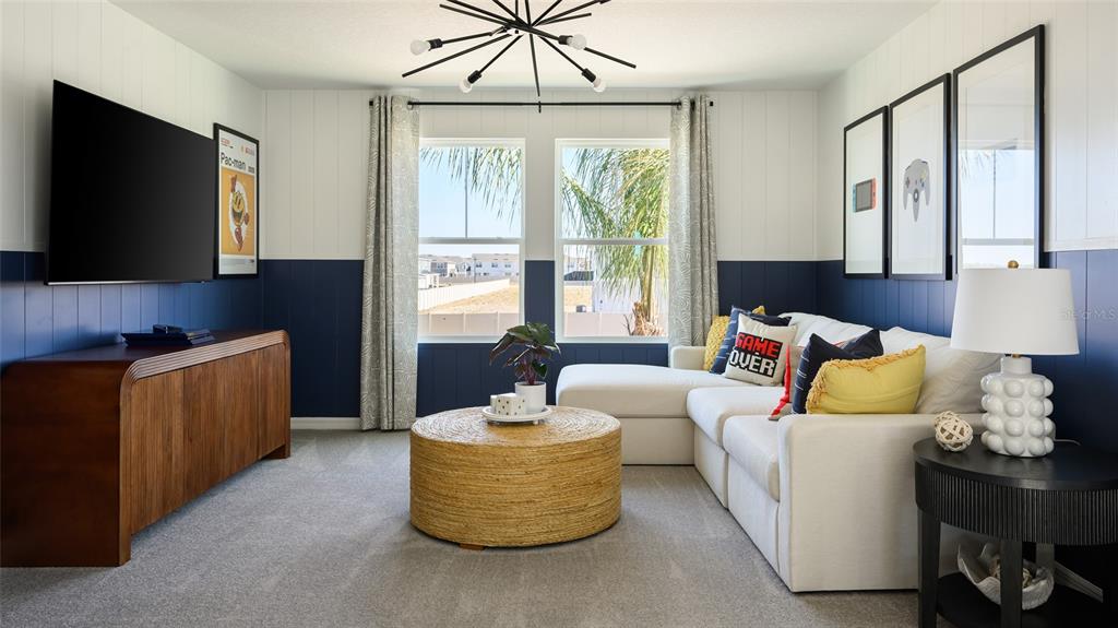 A living room features a white sectional sofa, a round woven coffee table, and blue wainscoting — 2358 STILLVIEW PASS, ZEPHYRHILLS, FL