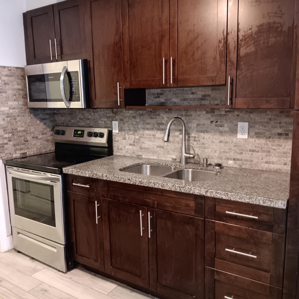 A kitchen features dark wood cabinets, stainless steel appliances, granite countertops, and a tiled backsplash — 4961 SW 28th Terrace # 2, Dania Beach FL 33004, DANIA BEACH, FL