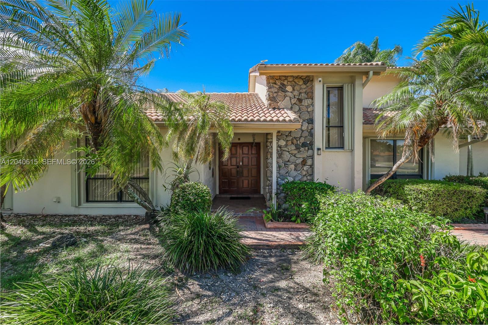 A single-story house features a stone facade, a tiled roof, and a double-door entrance — 14941 SW 164th Ter, Miami FL 33187, MIAMI, FL