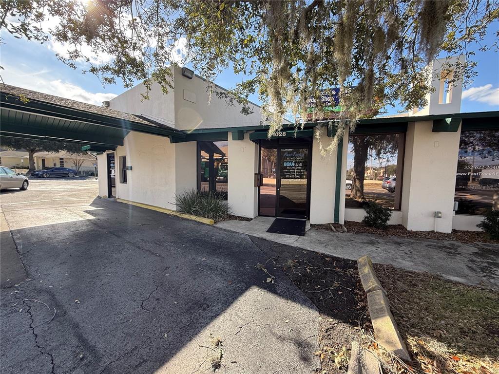 The exterior of a commercial building features a covered entrance and large glass windows — 1028 E SILVER SPRINGS BOULEVARD Bldg 1, OCALA, FL