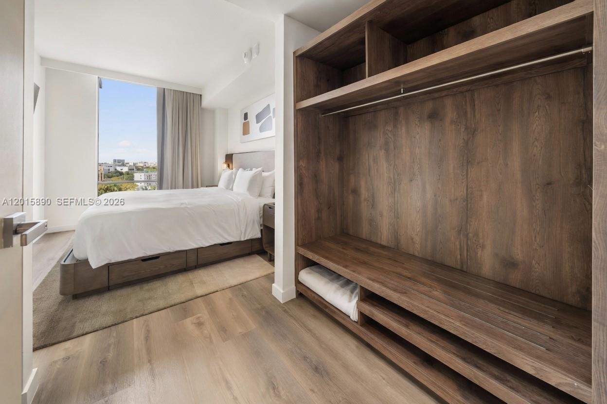 A bedroom features a wooden walk-in closet, a bed with storage drawers, and a window — 1611 SW 2nd Ave # 707, Miami FL 33129, MIAMI, FL