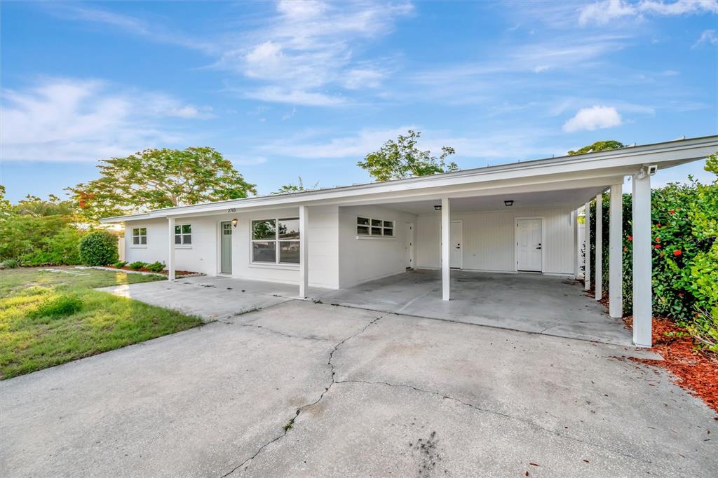A white single-story house with a concrete driveway and a covered carport — 2705 SUNNYSIDE STREET, SARASOTA, FL