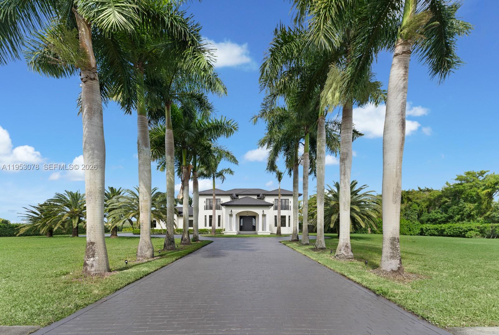 A paved driveway leads to a two-story house framed by rows of palm trees — 17805 SW 158th St, Miami FL 33187, MIAMI, FL