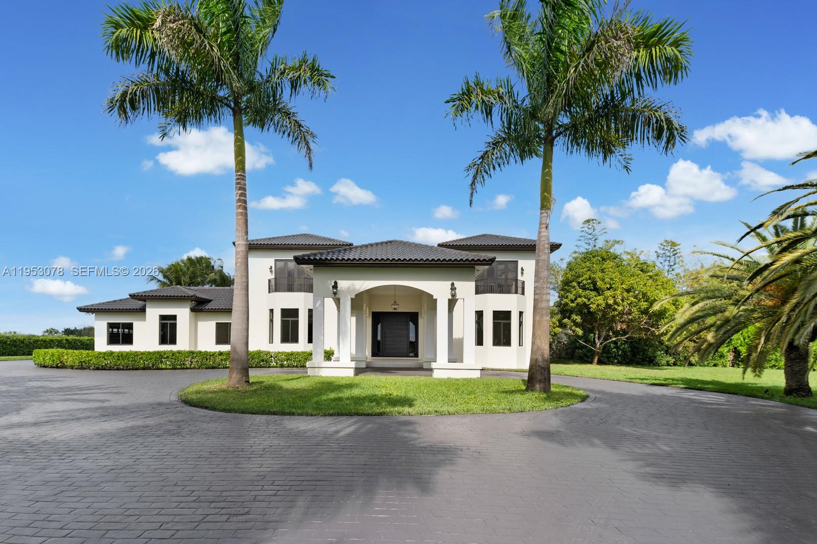 A two-story white house with a dark tile roof features a circular driveway and palm trees — 17805 SW 158th St, Miami FL 33187, MIAMI, FL