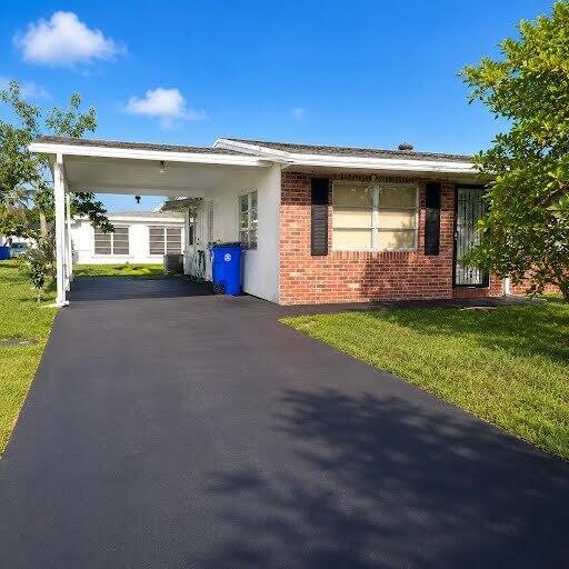 A single-story brick house features a large carport and a freshly paved black asphalt driveway — 1030 NW 73rd Avenue, Margate FL 33063, MARGATE, FL