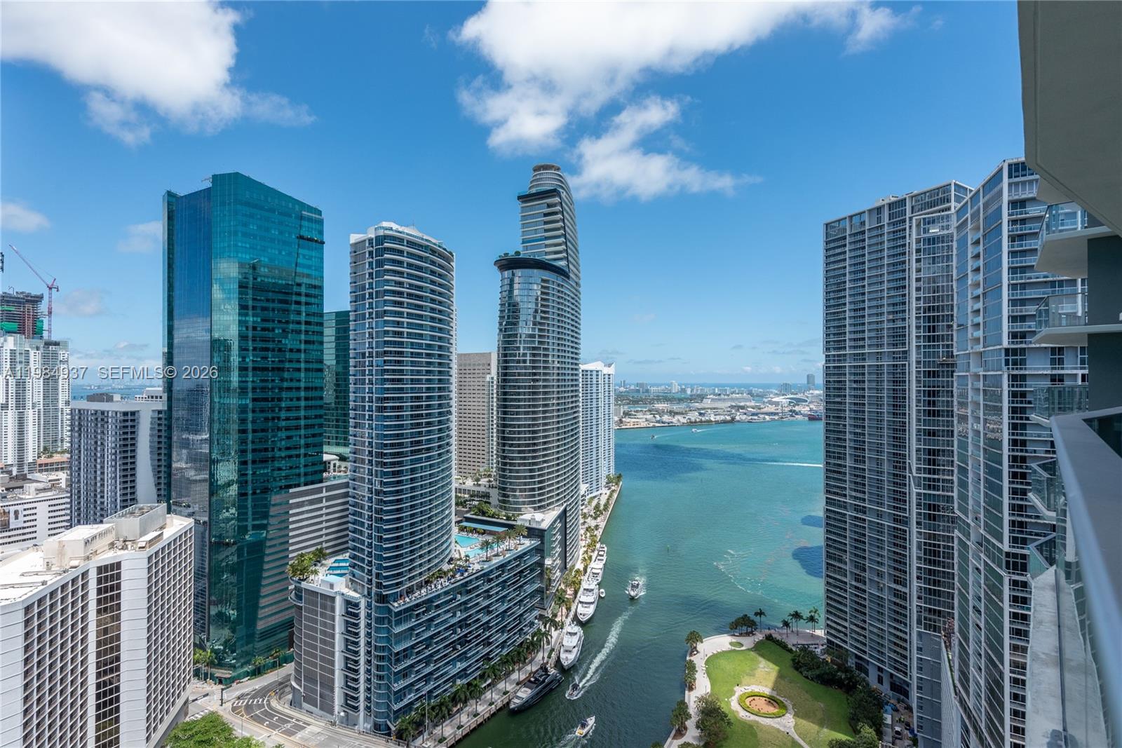An elevated view of a Miami waterfront cityscape featuring modern skyscrapers and a park — 77 SE 5th Street # 4004, Miami FL 33131, MIAMI, FL