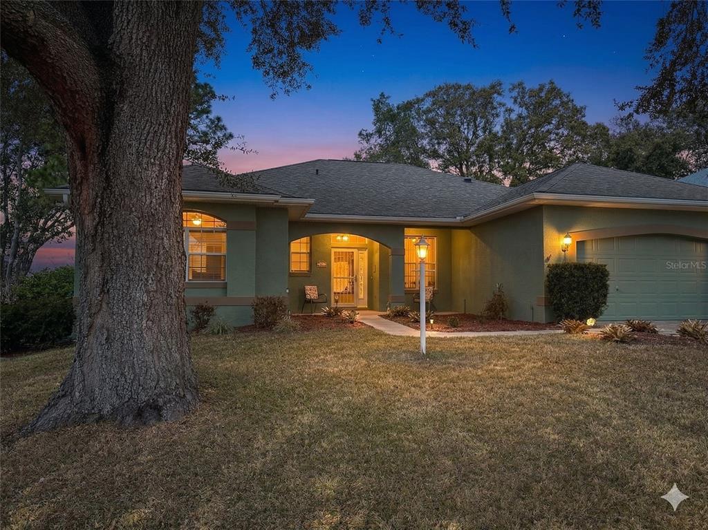 A single-story green house with a garage and a large tree in the front yard — 4614 N CRESTLINE DRIVE, BEVERLY HILLS, FL