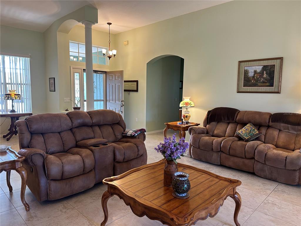 A living room features two brown reclining sofas, a wooden coffee table, and tile flooring — 4614 N CRESTLINE DRIVE, BEVERLY HILLS, FL