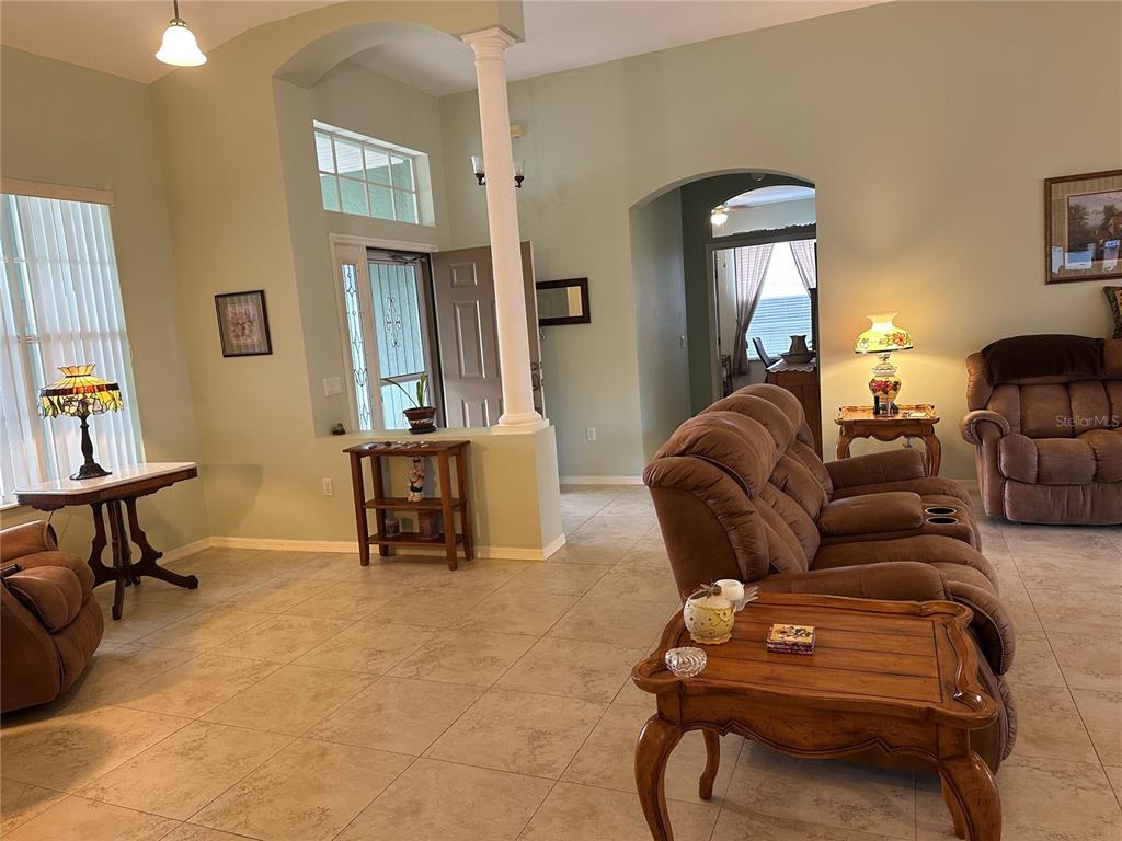 A living room with tile floors, brown furniture, and a white support column — 4614 N CRESTLINE DRIVE, BEVERLY HILLS, FL