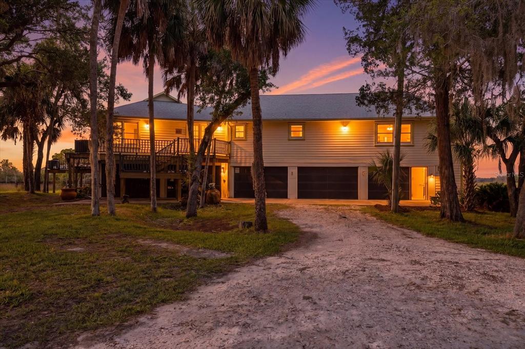 An aerial view shows a house situated on a marshy waterfront lot with a boardwalk — 12350 W RED MAPLE STREET, HOMOSASSA, FL