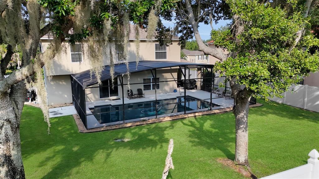An aerial view of a backyard featuring a screened-in swimming pool and a two-story house — 1702 FOREST GLEN DRIVE, FRUITLAND PARK, FL