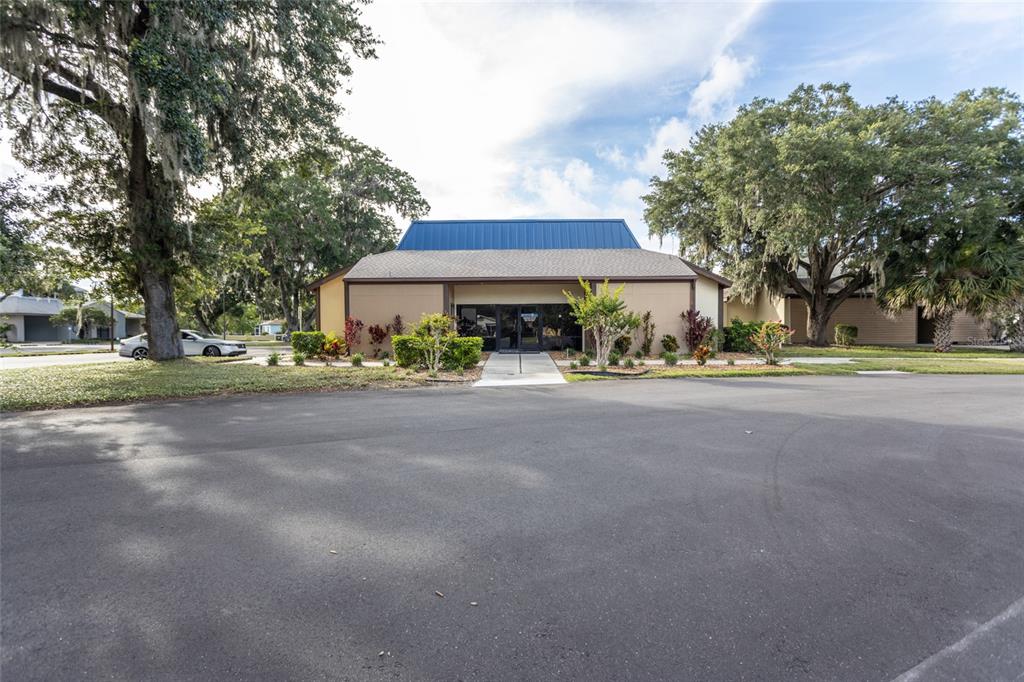 A single-story commercial building with a blue metal roof sits behind a paved parking lot — 26 OFFICE PARK DRIVE, PALM COAST, FL