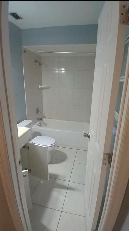 A bathroom features a white toilet, a vanity cabinet, and a shower-tub combination with tile — 5607 CHET DRIVE, ORLANDO, FL