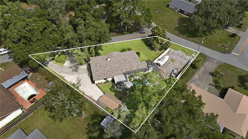 An aerial view shows a house with a pool enclosure, large yard, and driveway — 41300 DIXIE AVENUE, UMATILLA, FL