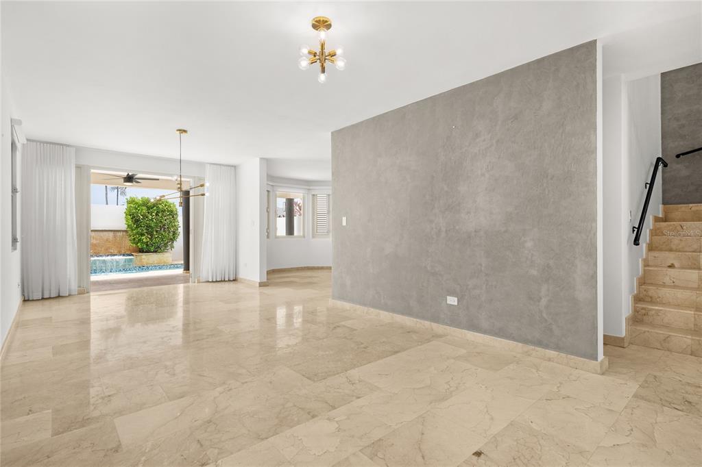 A bright living area features marble floors, a textured gray accent wall, and a staircase — J9 CALLE NATALIA, TRUJILLO ALTO, PR
