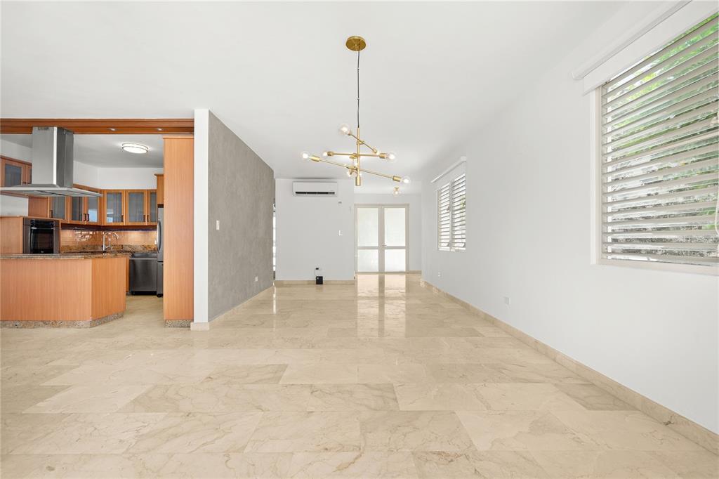 An open-concept living and dining area features light marble flooring and a modern gold chandelier — J9 CALLE NATALIA, TRUJILLO ALTO, PR
