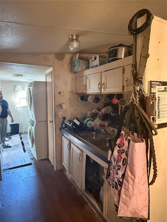 A kitchen area features a double sink, upper cabinets, and a stacked washer and dryer — 108 KITTY AVENUE, INTERLACHEN, FL