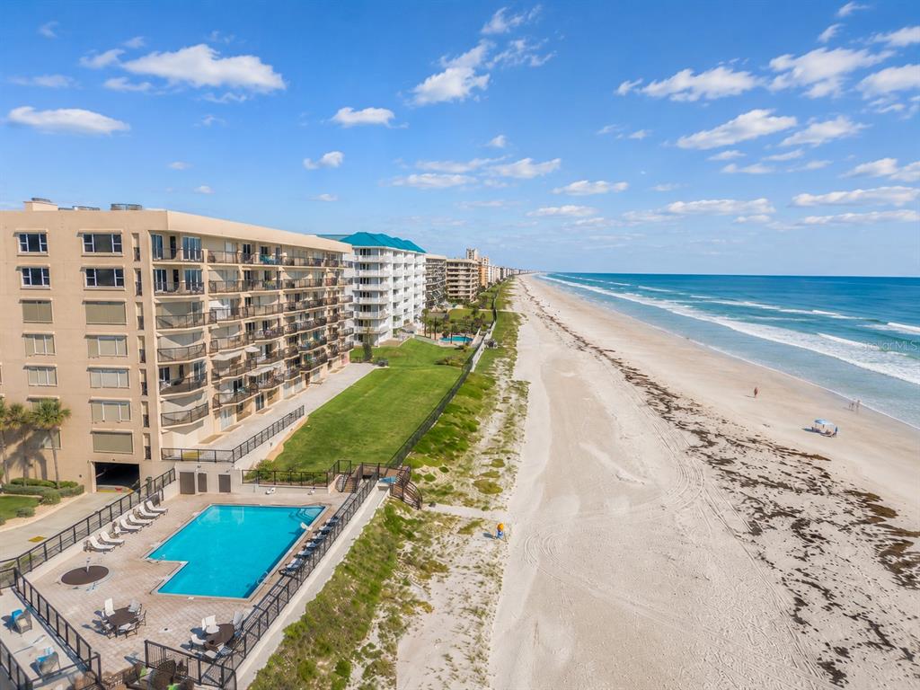 An aerial view of a beachfront condominium complex with a swimming pool and sandy beach — 4651 S ATLANTIC AVENUE UNIT 9203, PONCE INLET, FL