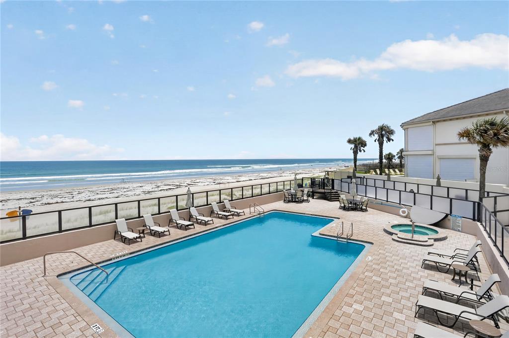 An outdoor swimming pool and hot tub overlook the beach from a paved patio — 4651 S ATLANTIC AVENUE UNIT 9203, PONCE INLET, FL