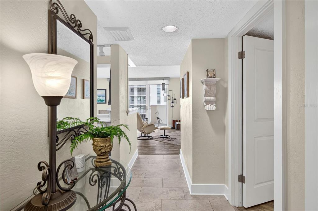 A tiled entryway leads into a living area with a balcony visible through sliding doors — 3047 S ATLANTIC AVENUE UNIT 705, DAYTONA BEACH, FL