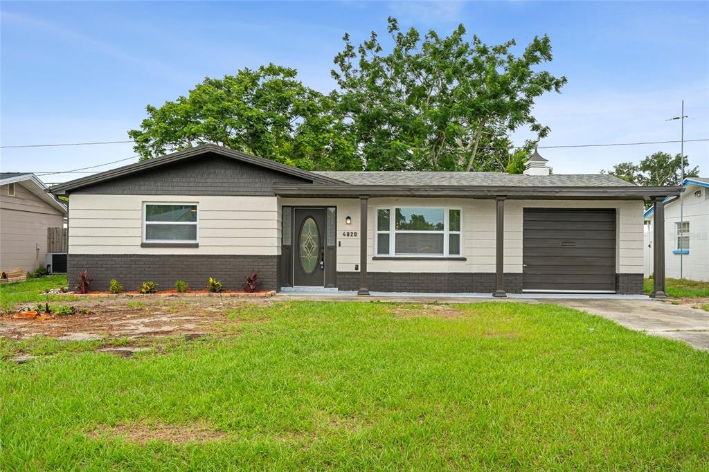 A single-story house with a dark brown garage, gray siding, and a front porch — 4820 SALEM DRIVE, NEW PORT RICHEY, FL