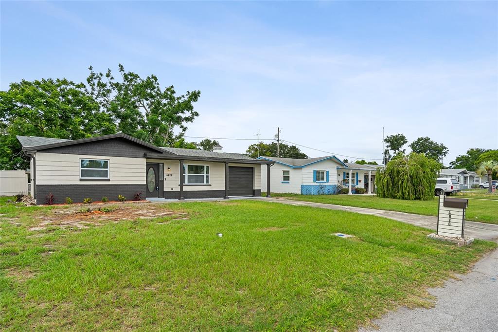 A single-story house with a two-tone exterior and a front-facing garage sits on a lawn — 4820 SALEM DRIVE, NEW PORT RICHEY, FL