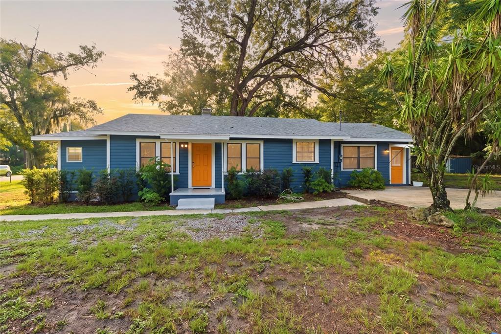 A blue single-story house with a bright orange front door and a large tree — 2206 PAGE AVENUE, ORLANDO, FL