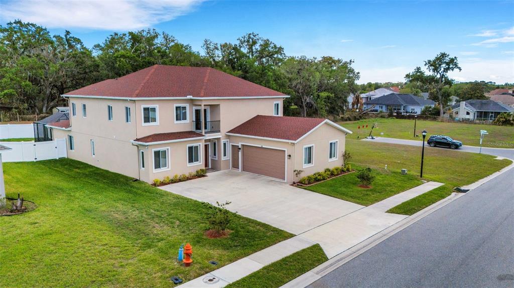 A two-story tan house with a red roof, a two-car garage, and a concrete driveway — 545 GANDHI DRIVE, LAKELAND, FL