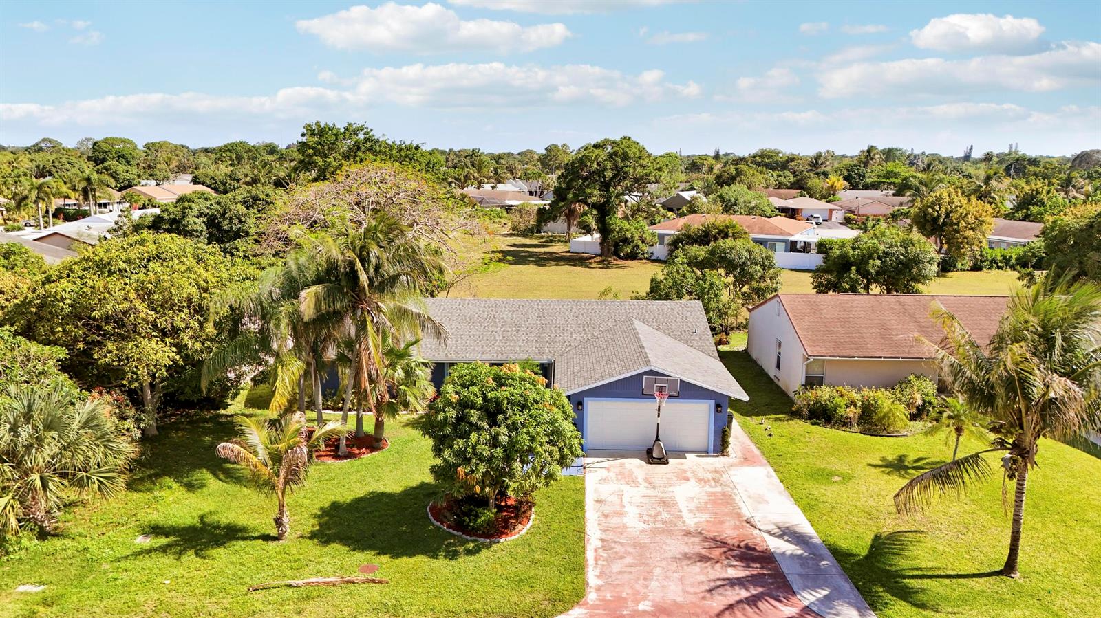 An aerial view shows a blue single-story house with a two-car garage and driveway — 3336 Ave Villandry, Delray Beach FL 33445, DELRAY BEACH, FL