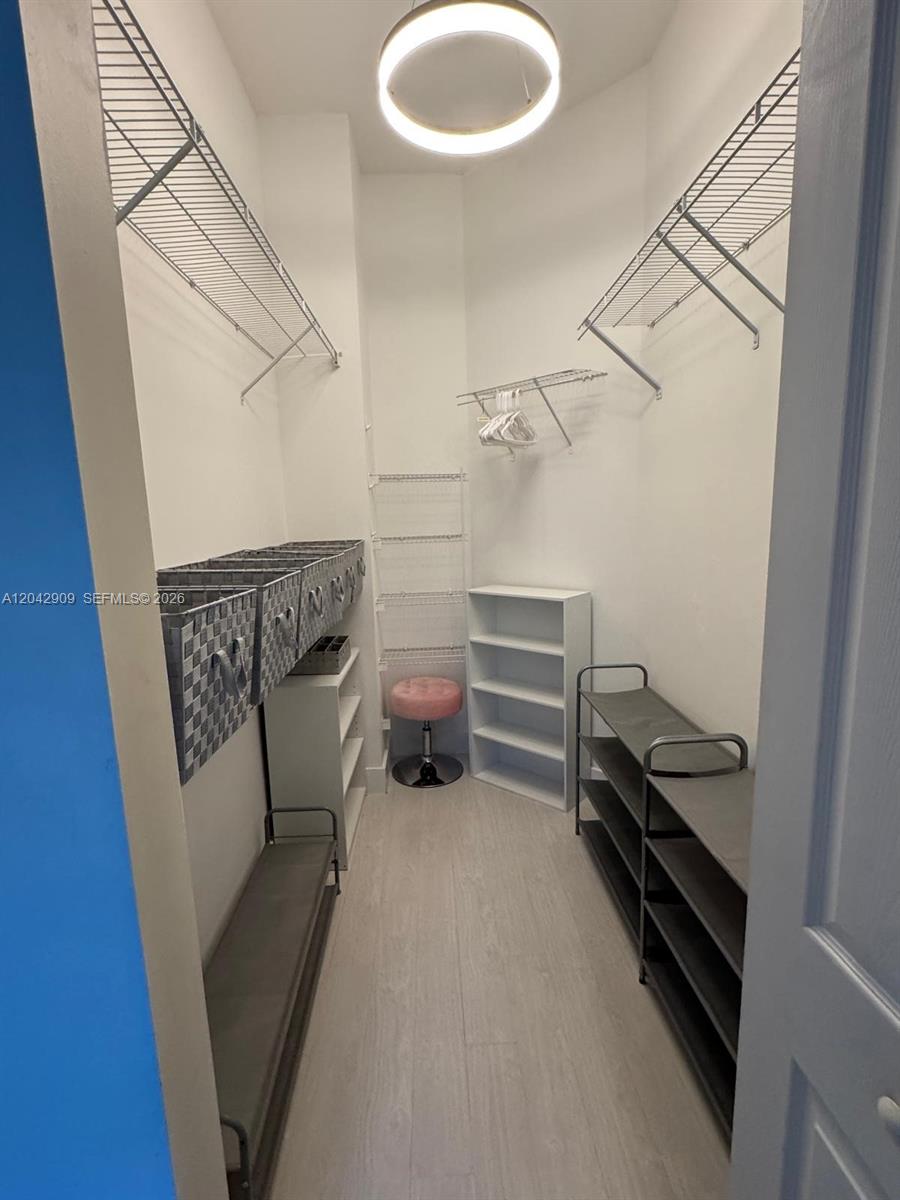 A walk-in closet features wire shelving, a small vanity stool, and open shoe racks — 4602 SW 160th Ave # 521, Miramar FL 33027, MIRAMAR, FL