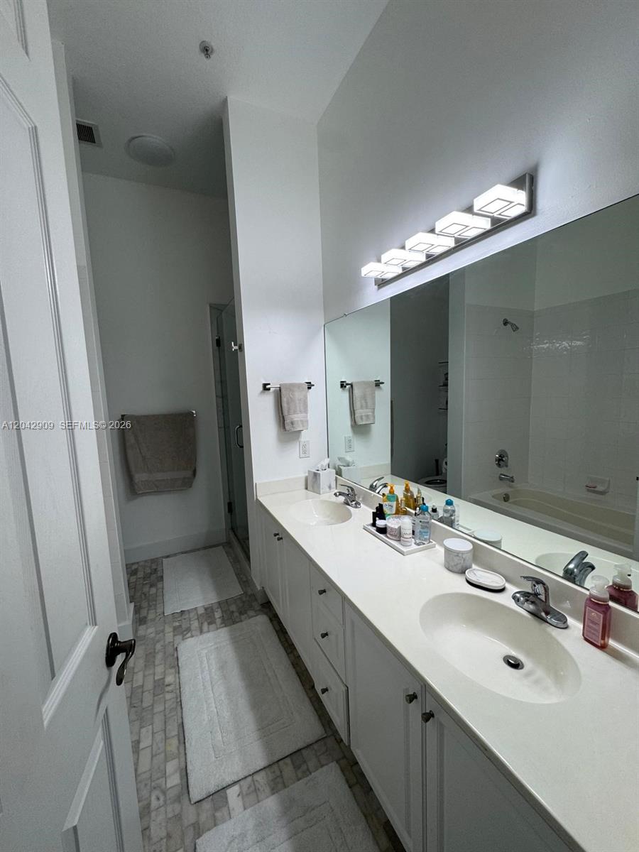 A bathroom features a double vanity with white cabinets, a large mirror, and a shower — 4602 SW 160th Ave # 521, Miramar FL 33027, MIRAMAR, FL