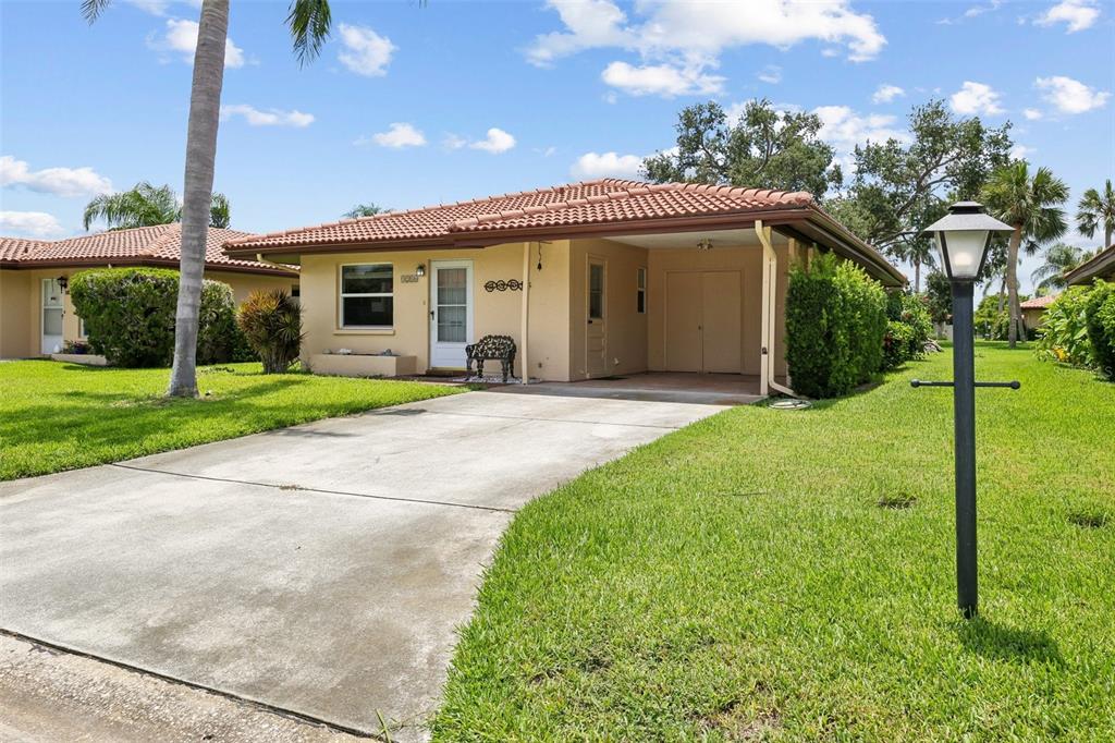 A single-story house with a terracotta tile roof, a carport, and a concrete driveway — 3210 CAMBRIDGE AVENUE, BRADENTON, FL
