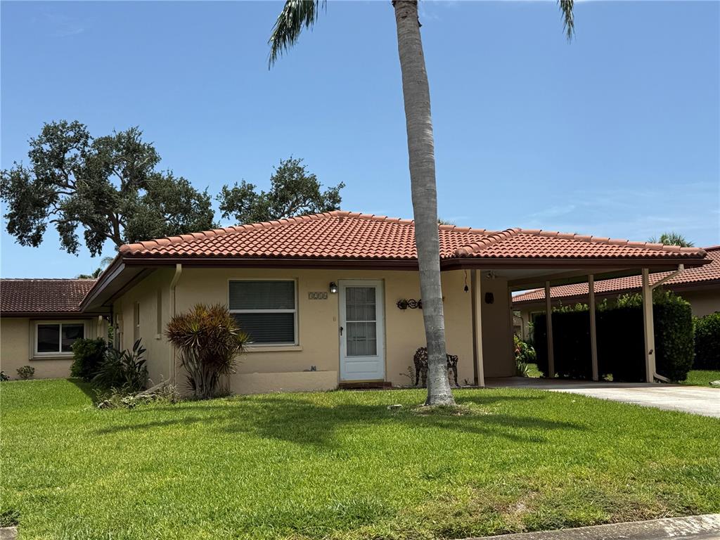 A single-story house with a terracotta tile roof, a carport, and a palm tree — 3210 CAMBRIDGE AVENUE, BRADENTON, FL