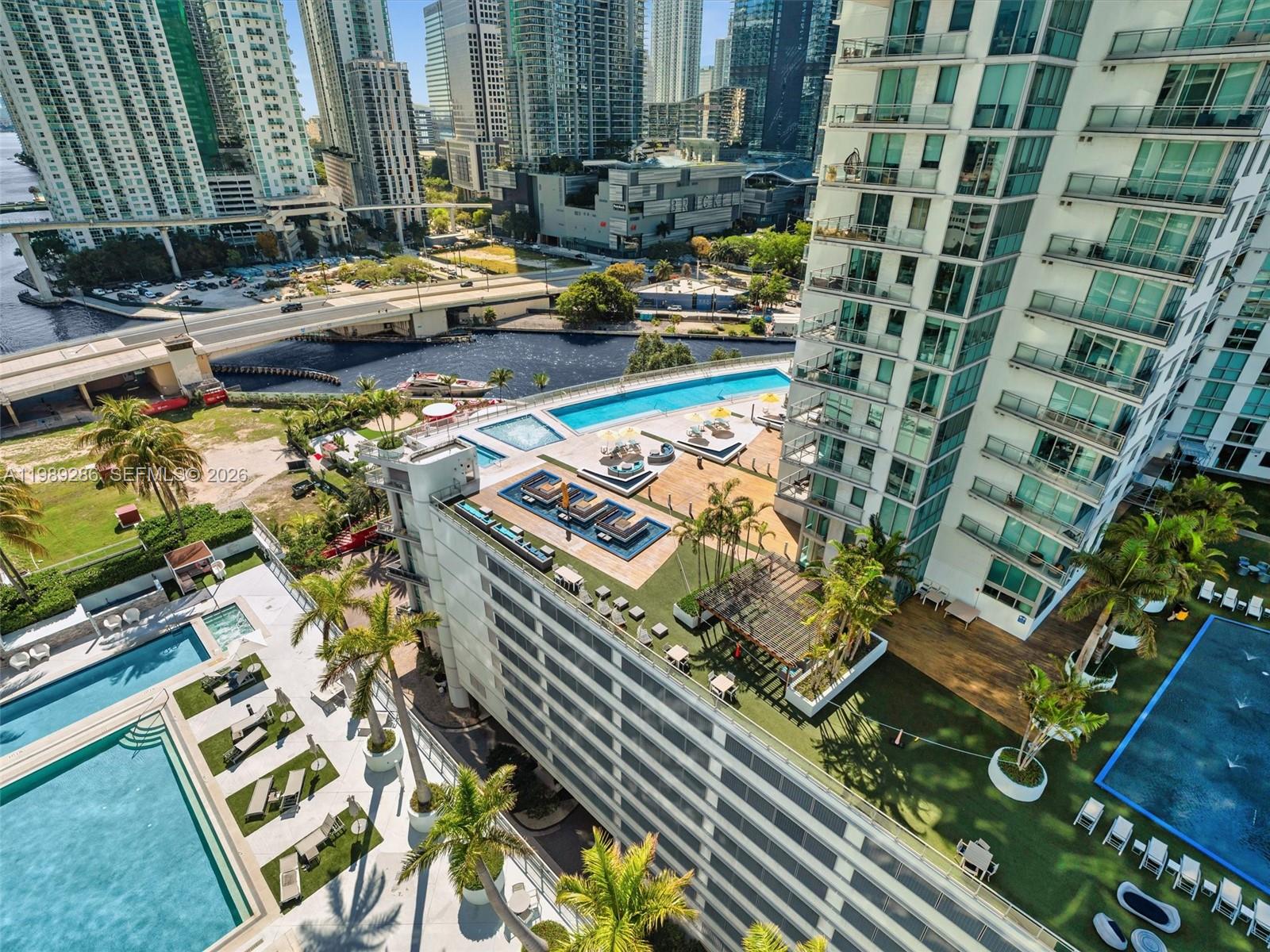 An aerial view of a high-rise building with multiple swimming pools and rooftop lounge areas — 90 SW 3rd St # 2013, Miami FL 33130, MIAMI, FL