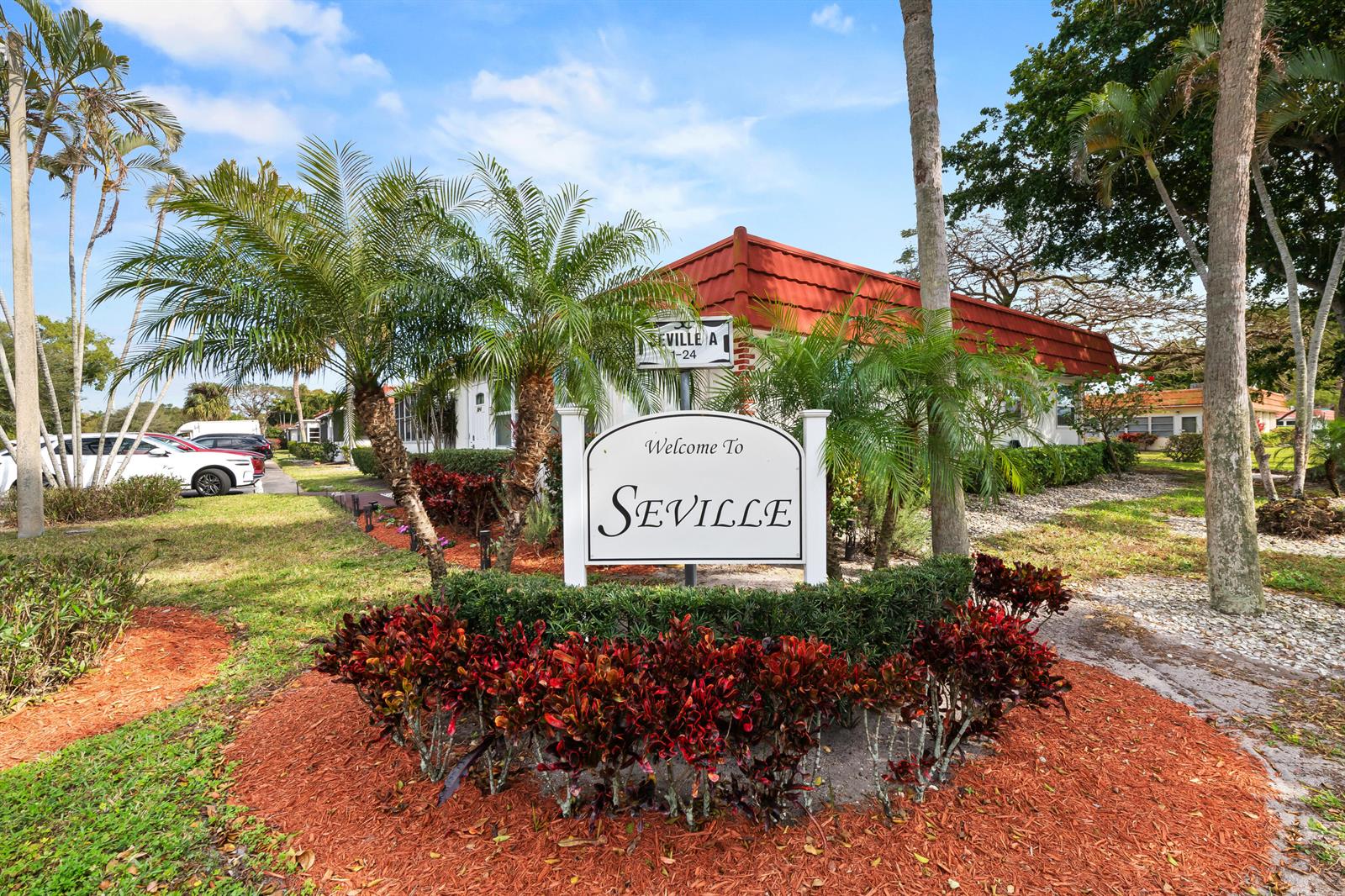 A sign reading Welcome To Seville stands in front of a building with a red roof — 4 Seville Terrace # 4, Delray Beach FL 33446, DELRAY BEACH, FL